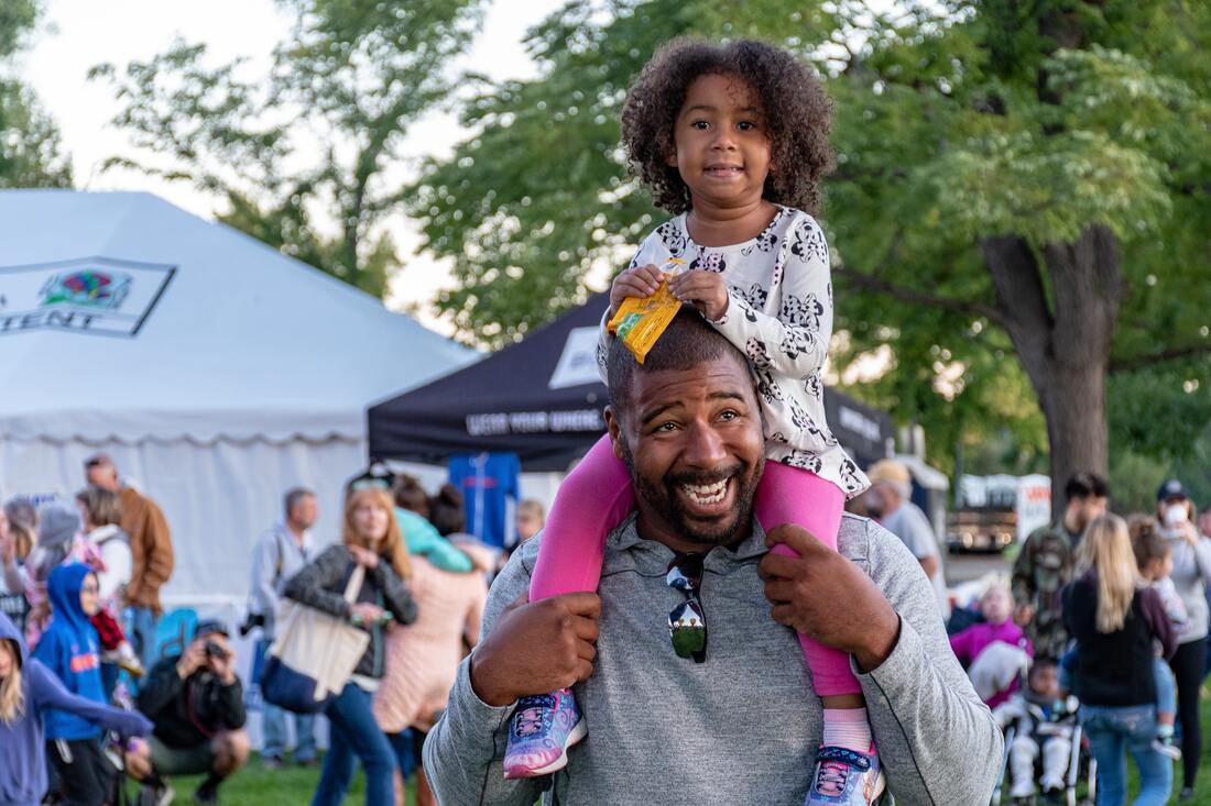 Father Carrying His Daughter On His Shoulders At A Festival | Advanced Therapy Institute of Touch